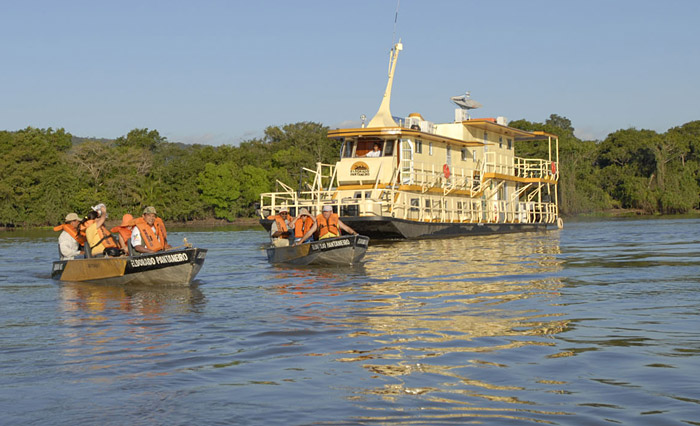 Visitors exploring the Pantanal near Cáceres, in front of a small Barco-Hotel.
